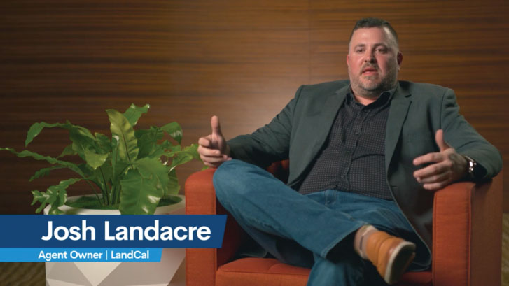 A person sits in an orange chair, sporting a dark blazer and checkered shirt as they gesture animatedly. Nearby, a large potted plant adds ambiance. The screen displays Josh Landacre, Agent Owner | LandCal, and the opportunity to Become a Freight Agent.