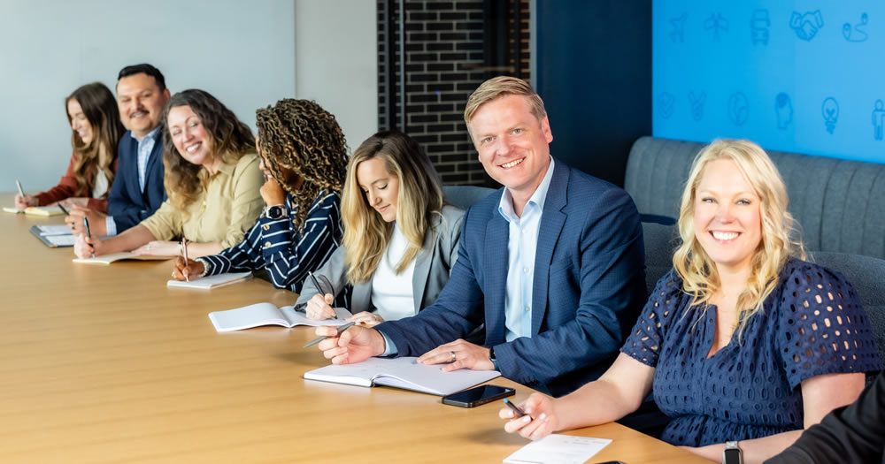 An informational flyer for GlobalTranz’s Freight Agent support program, featuring agent support services, benefits, a testimonial, contact info, and images of business professionals along the bottom. The design uses blue, white, and green accents.