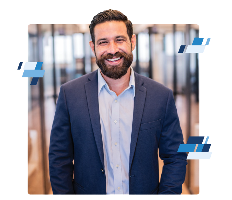 A man with dark hair and a beard, wearing a blue suit jacket and light shirt, smiles while standing in a modern office hallway—ideal for professionals in the logistics industry. Blue geometric shapes decorate the image corners.